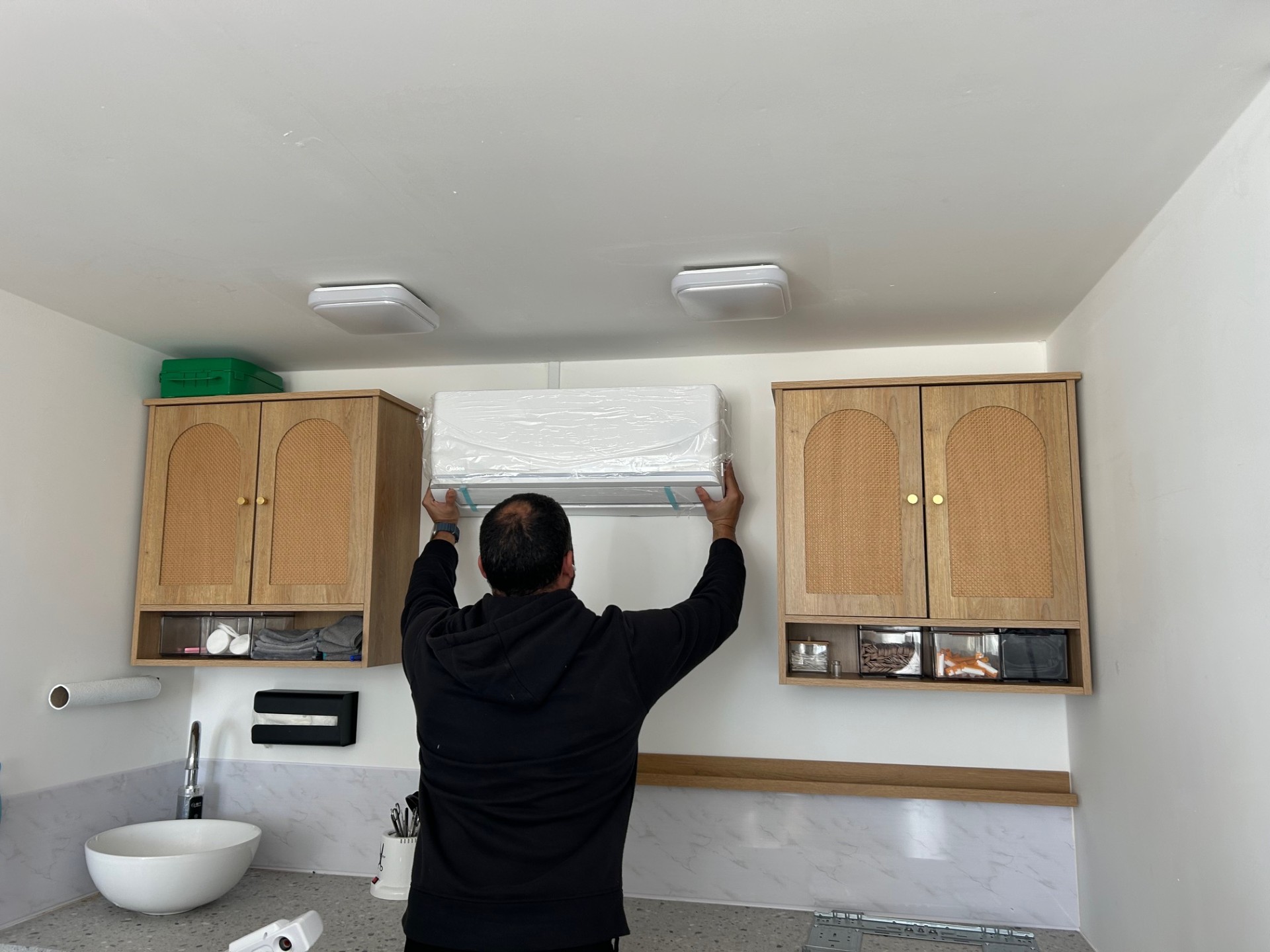 Wall-mounted air conditioning unit being fitted indoors